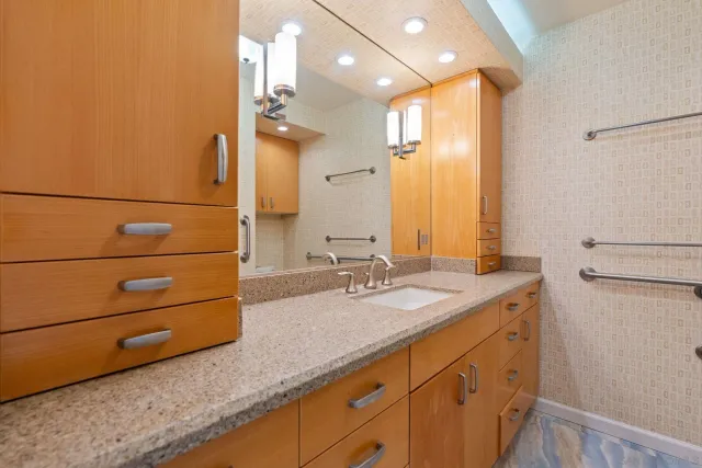 a bathroom with a granite countertop sink and a mirror