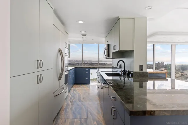 a kitchen with stainless steel appliances granite countertop a sink a stove and a refrigerator