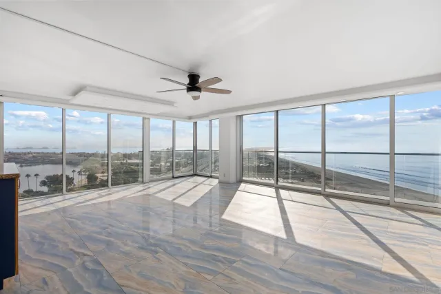 a room with lots of windows and a ceiling fan