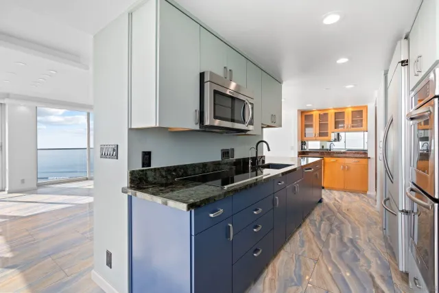 a kitchen with stainless steel appliances granite countertop a stove a sink and a microwave