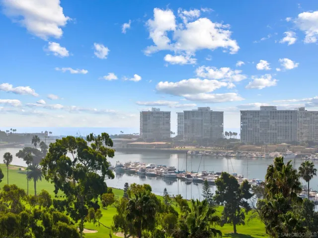 a view of a lake with a big yard and large trees