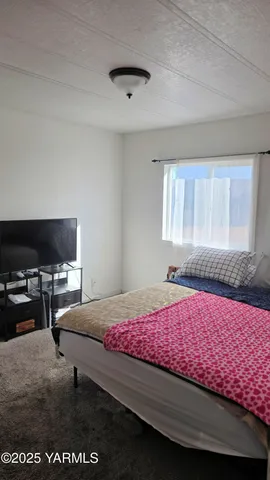 a bedroom with a bed and flat screen tv