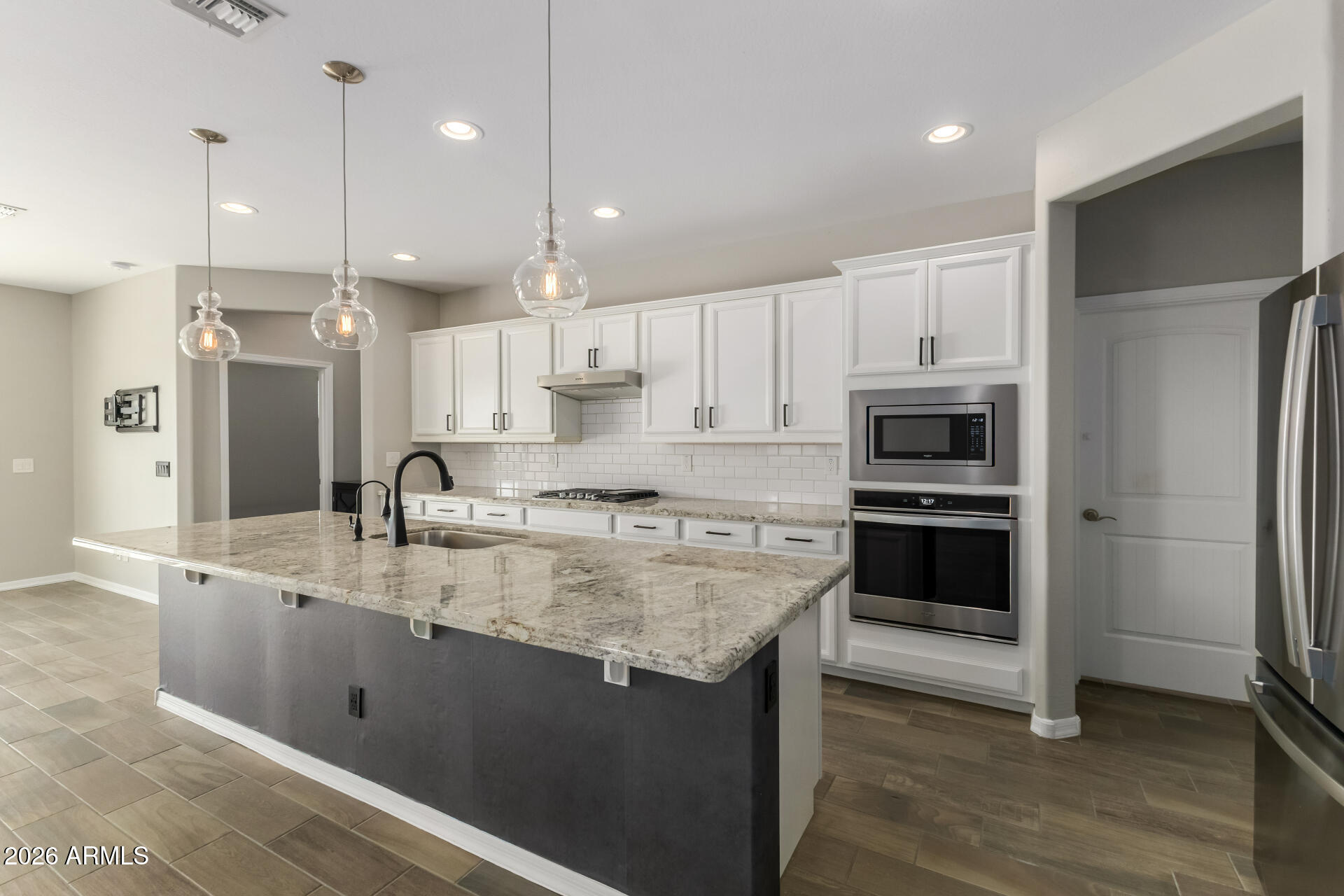 17771 West Granite View Drive Goodyear, AZ 85338 - Photo 12 of 35 a kitchen with kitchen island a sink stainless steel appliances and cabinets
