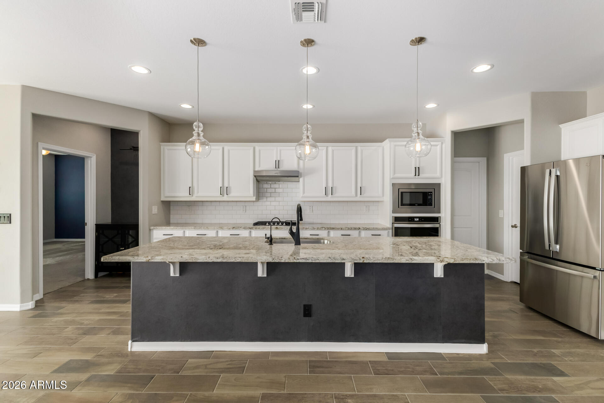 17771 West Granite View Drive Goodyear, AZ 85338 - Photo 13 of 35 a kitchen with stainless steel appliances granite countertop a refrigerator a sink a stove and oven with wooden floor