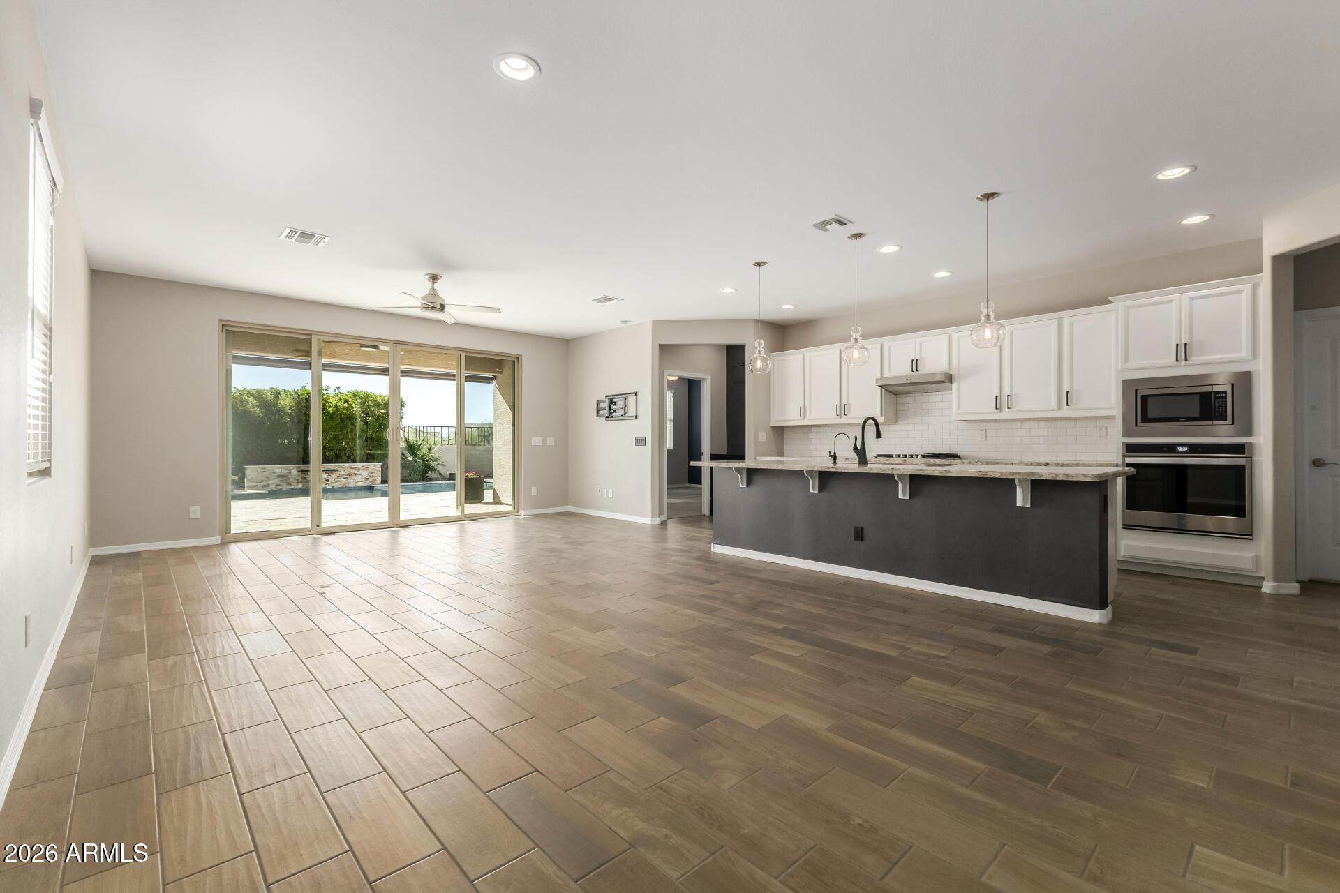 17771 West Granite View Drive Goodyear, AZ 85338 - Photo 7 of 35 a large kitchen with stainless steel appliances granite countertop a large counter top and a wooden floors