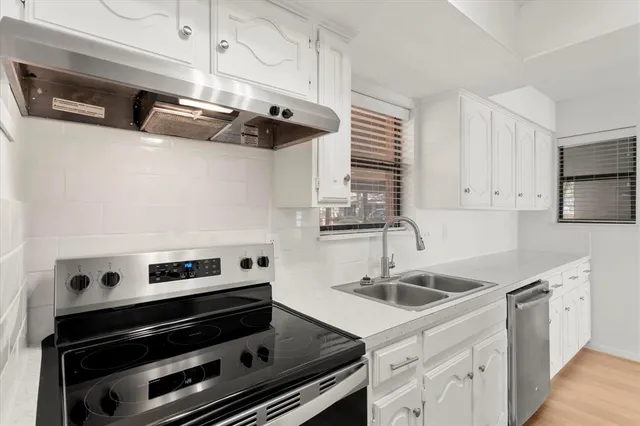 a kitchen with white cabinets and white appliances