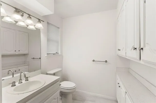 an empty room with windows and cabinet