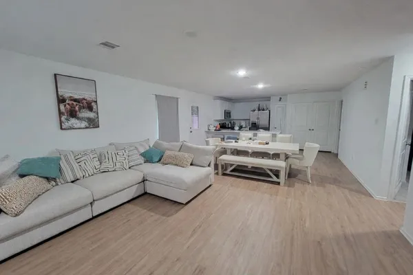 a living room with furniture and a wooden floor