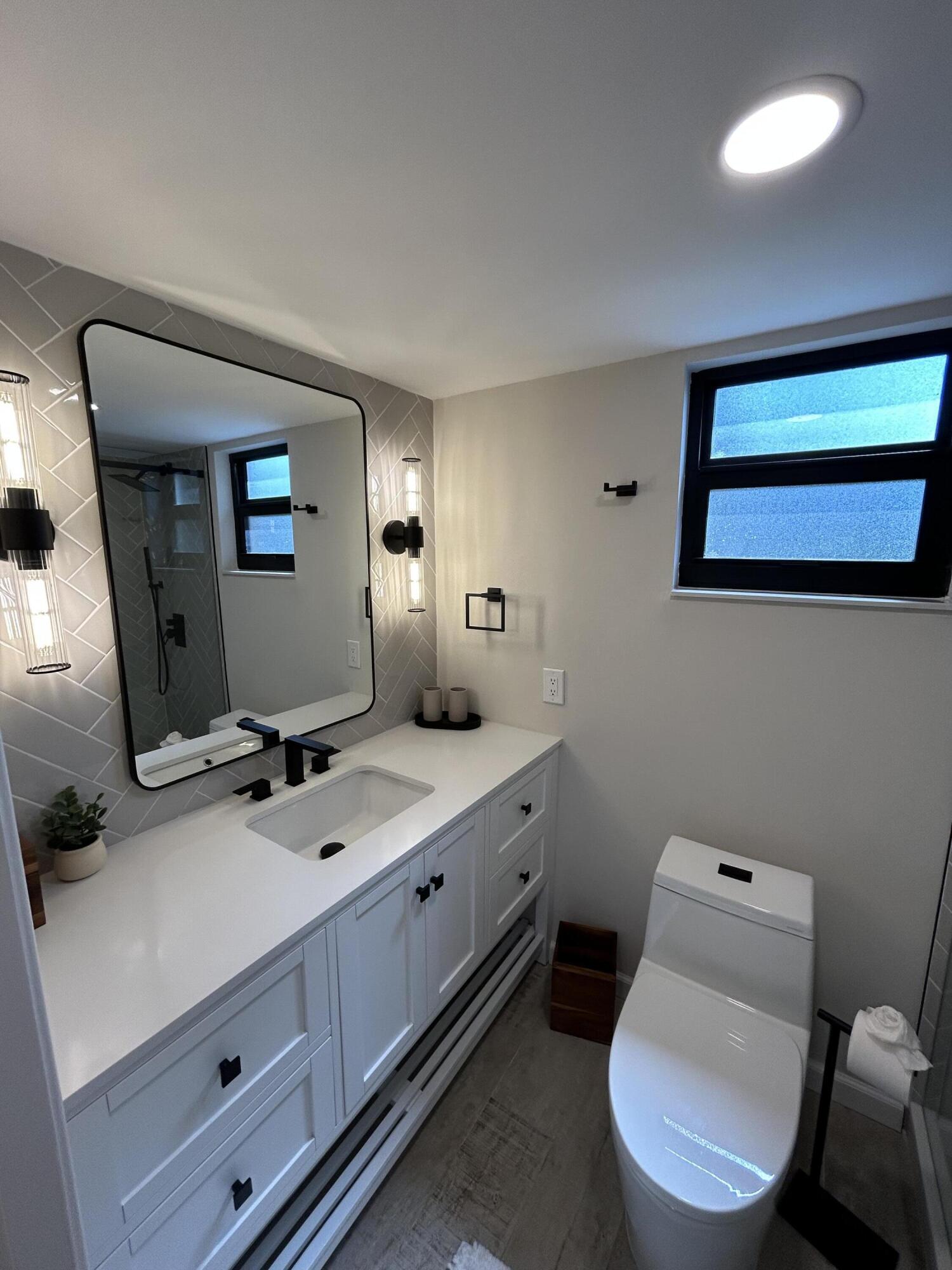 13334 Polo Club Road, Unit 203 Wellington, FL 33414 - Photo 11 of 19 a bathroom with a toilet sink and mirror