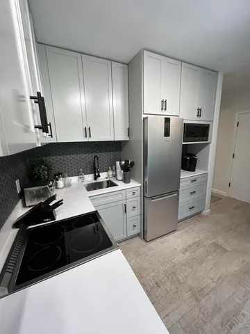 a kitchen with a sink a stove a refrigerator and cabinets