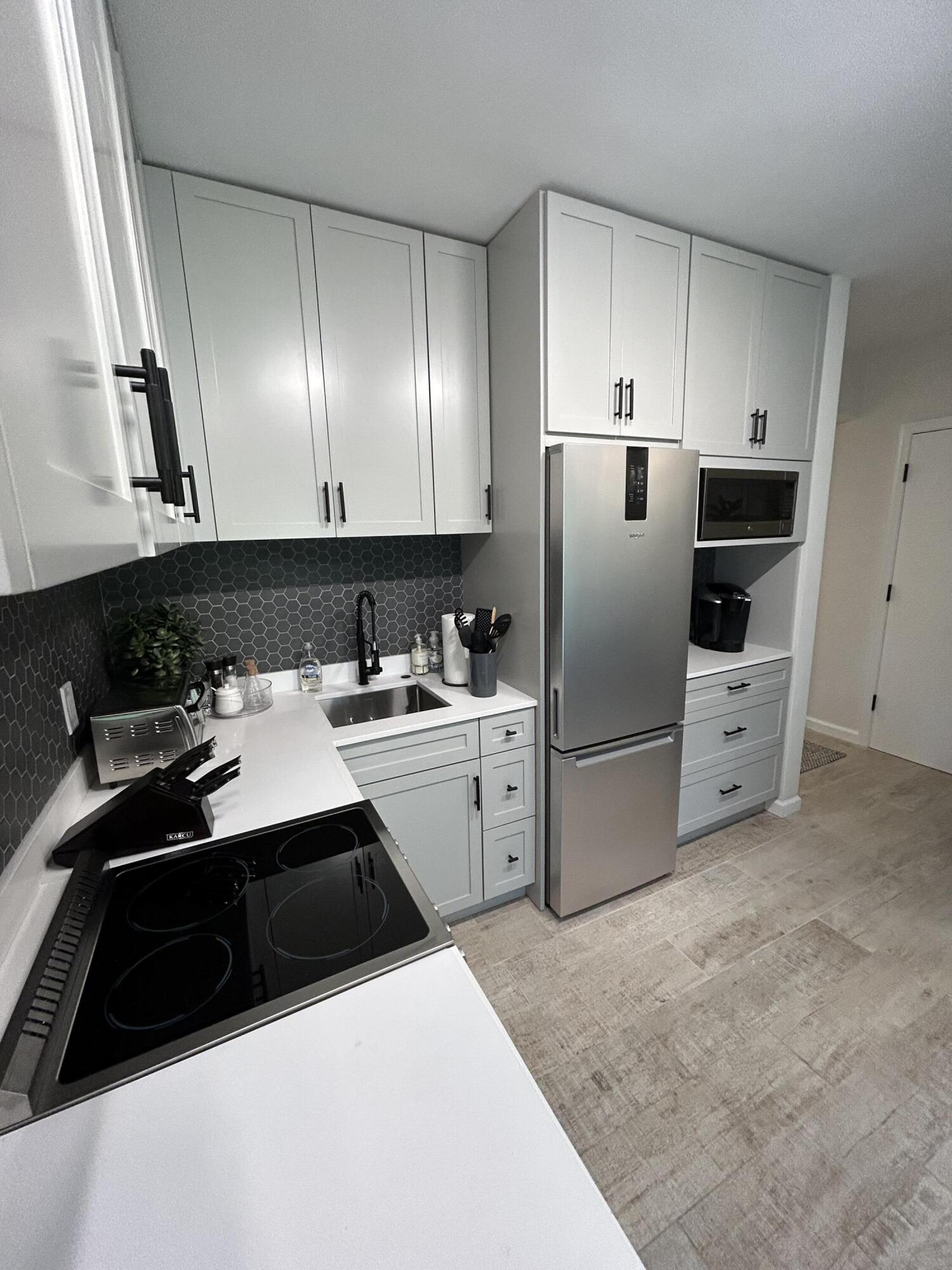 13334 Polo Club Road, Unit 203 Wellington, FL 33414 - Photo 3 of 19 a kitchen with a sink a stove a refrigerator and cabinets