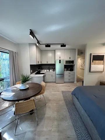 a living room with stainless steel appliances kitchen island furniture and a view of kitchen