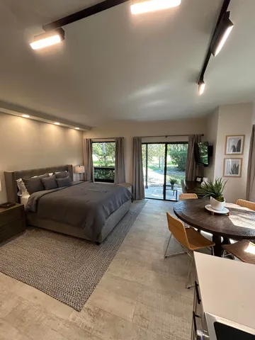 a living room with furniture a large window and a flat screen tv