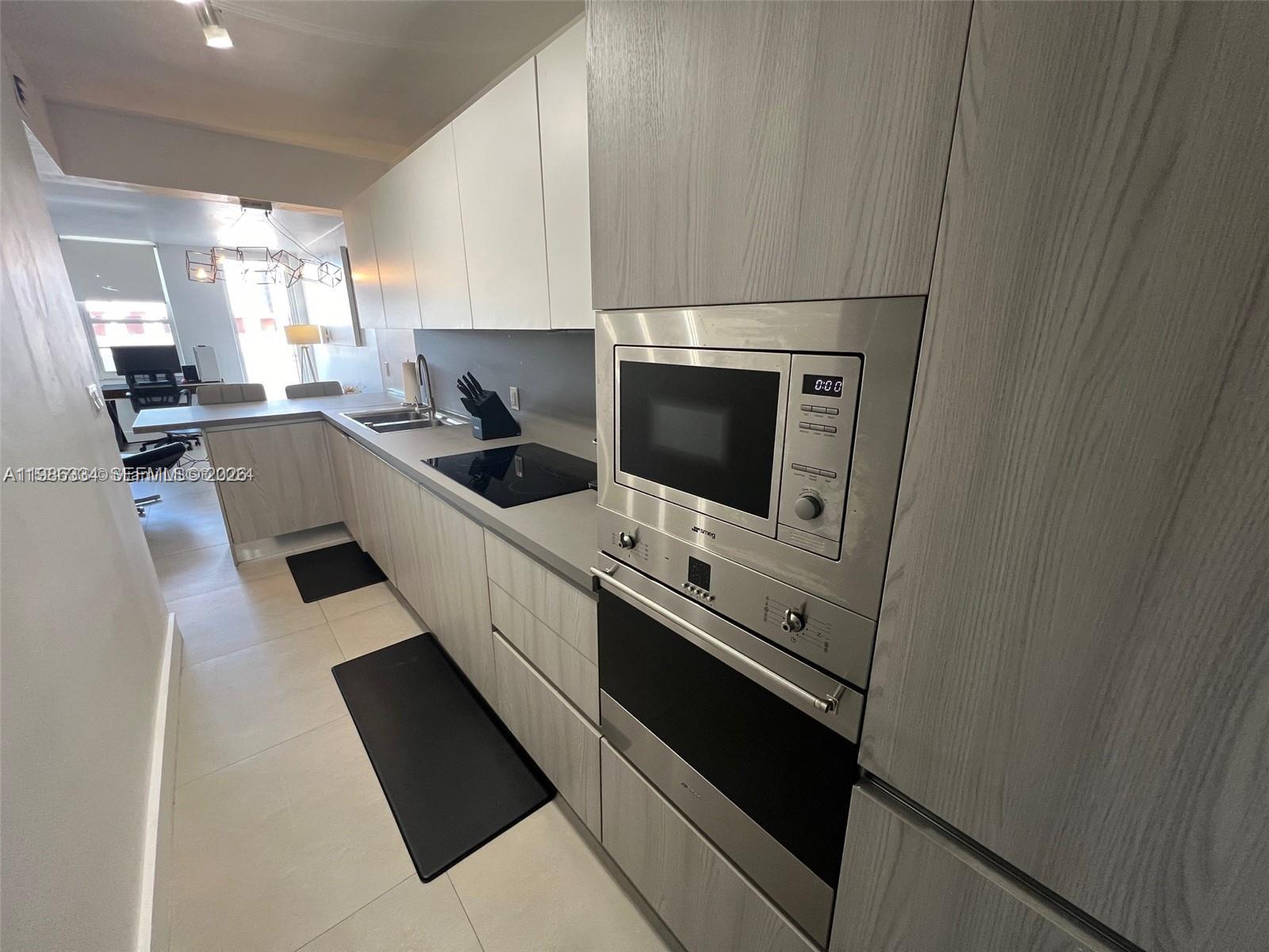 100 Lincoln Road, Unit 620 Miami Beach, FL 33139 - Photo 3 of 19 a kitchen with stainless steel appliances a sink stove and cabinets