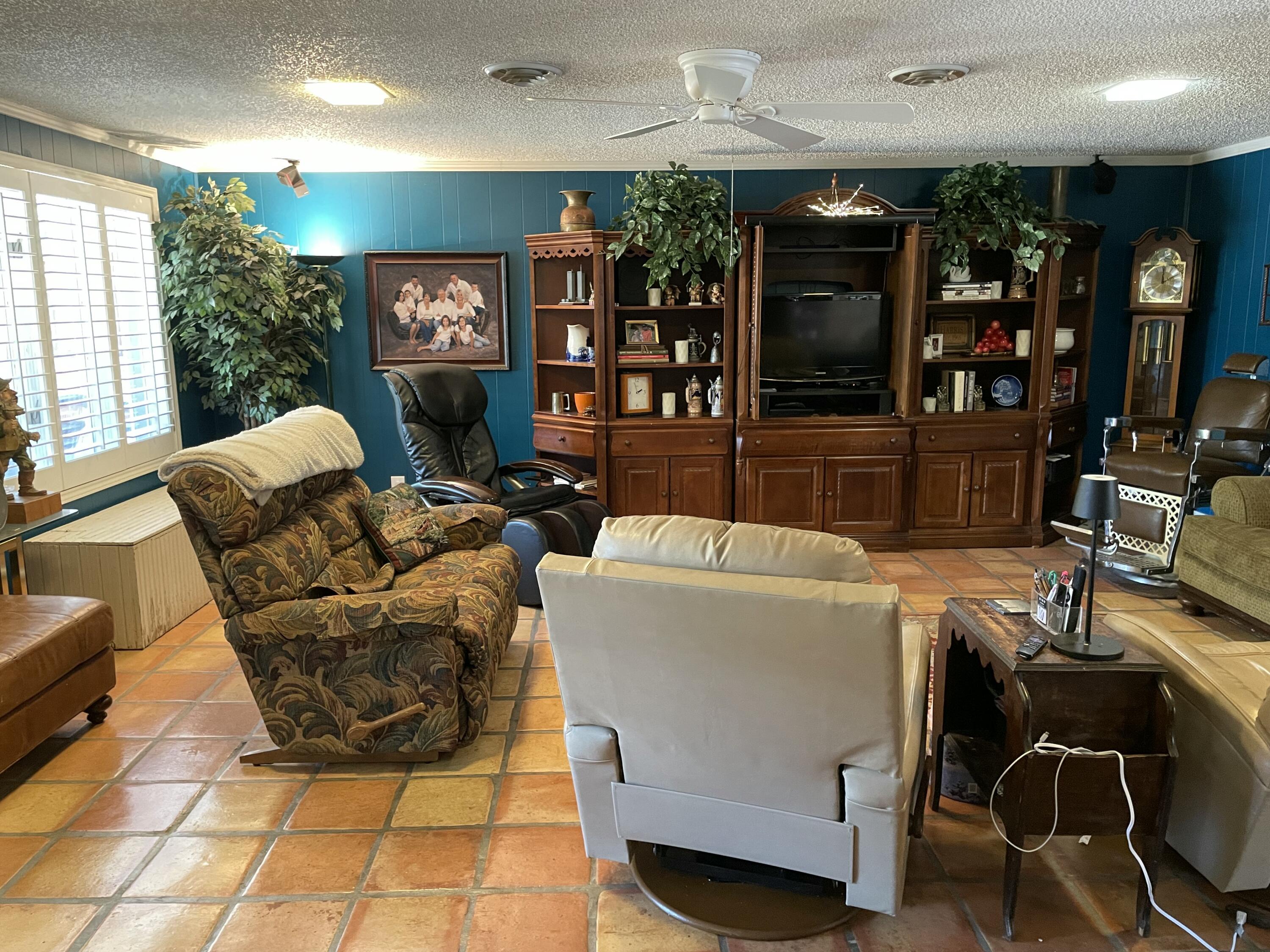 3206 21st Street Lubbock, TX 79410 - Photo 32 of 70 a living room with furniture a flat screen tv and a floor to ceiling window