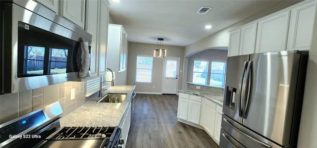 a kitchen with a refrigerator and a stove top oven