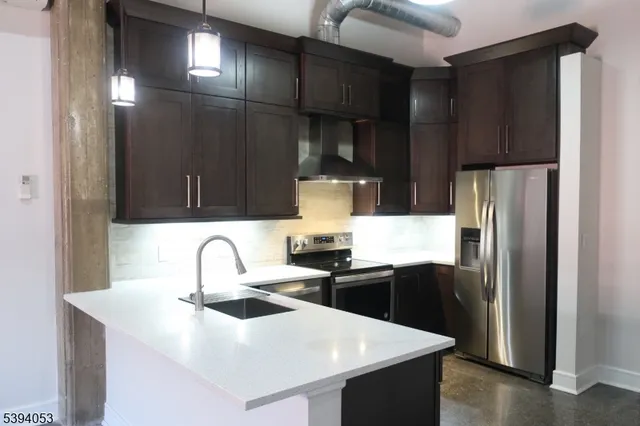a kitchen with stainless steel appliances a sink and a refrigerator