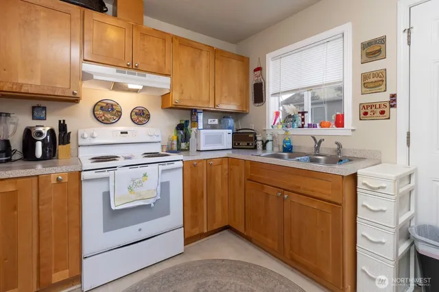 a kitchen with stainless steel appliances granite countertop a stove a sink and a refrigerator