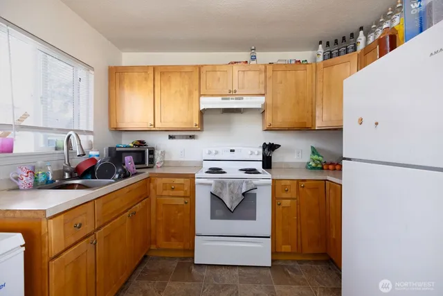 a kitchen with a sink a stove and cabinets
