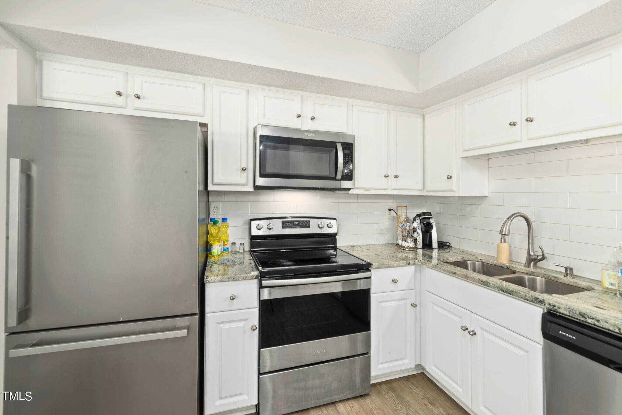 5955 Dixon Drive Raleigh, NC 27609 - Photo 5 of 26 a kitchen with cabinets stainless steel appliances and a sink