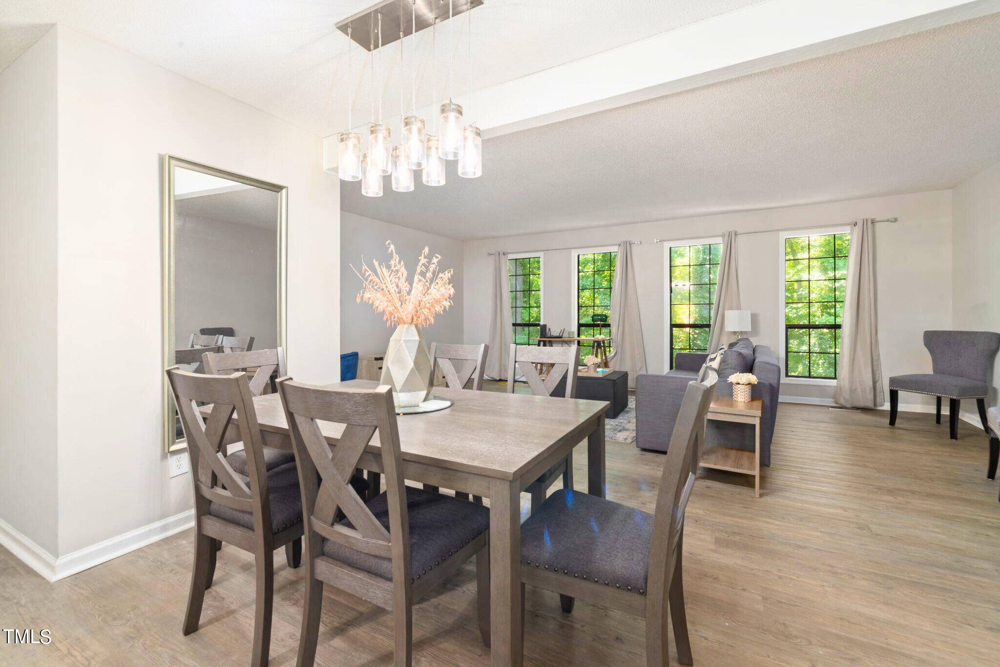 5955 Dixon Drive Raleigh, NC 27609 - Photo 9 of 26 a view of a dining room with furniture a chandelier and wooden floor