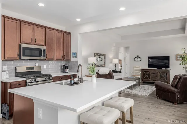 a kitchen with a stove a sink a microwave a dining table and chairs