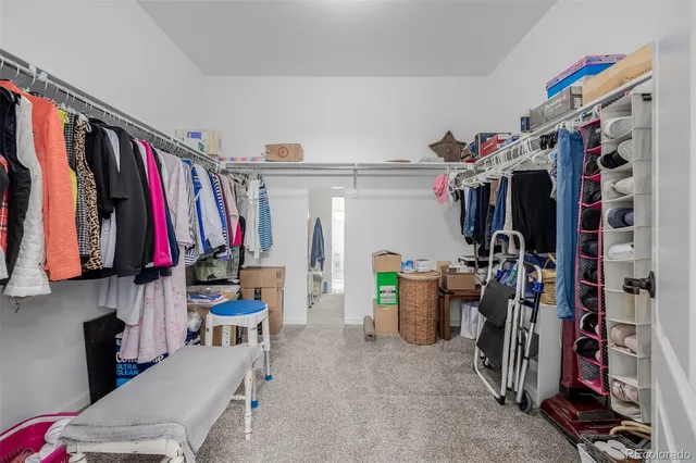 a view of walk in closet with clothes and shoes