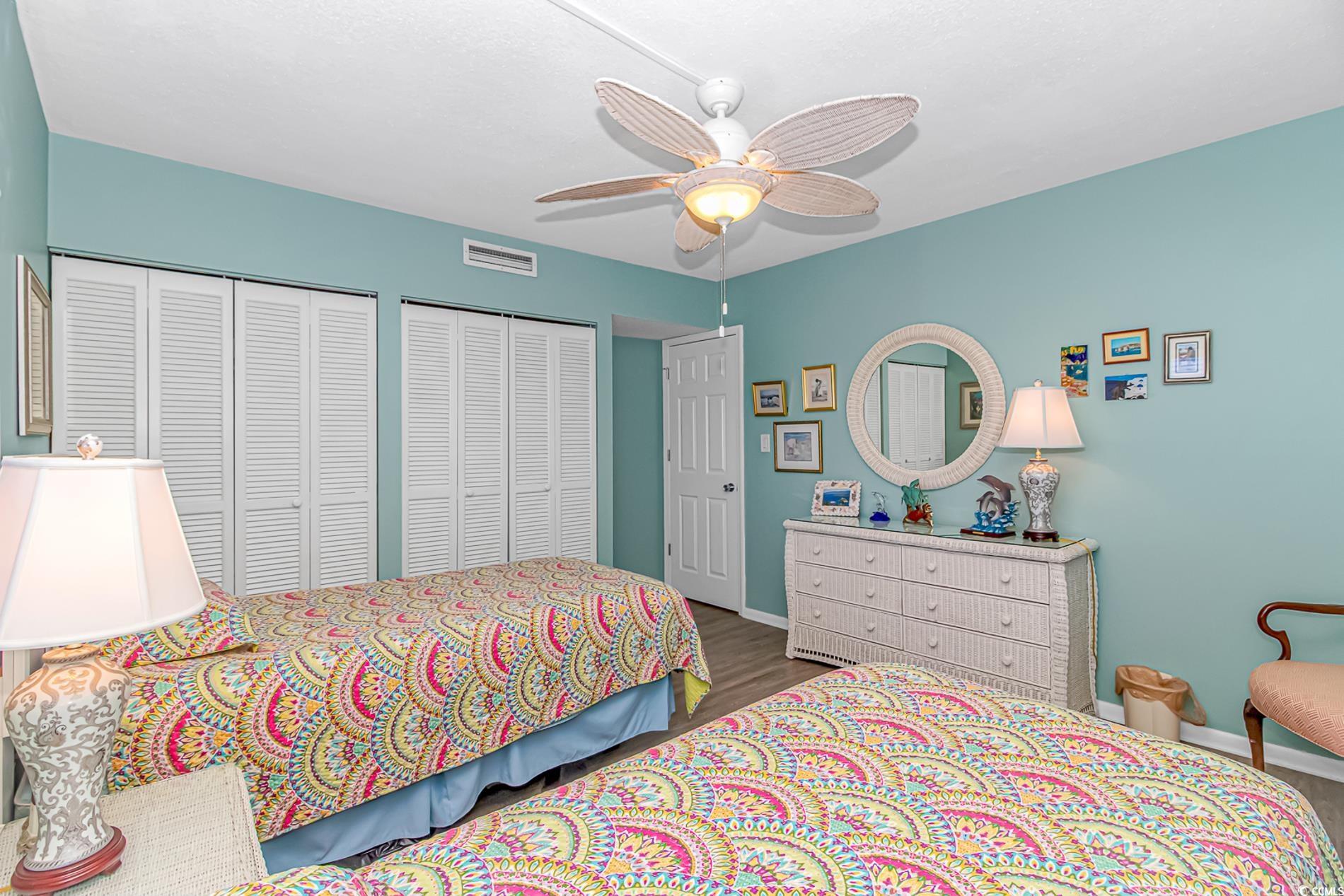 10100 Beach Club Drive, Unit 2B Myrtle Beach, SC 29572 - Photo 12 of 30 Bedroom featuring multiple closets, wood finished floors, and a ceiling fan