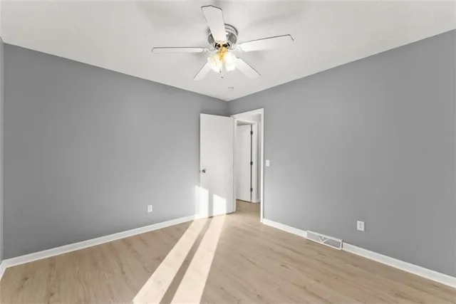 a view of an empty room with a chandelier fan