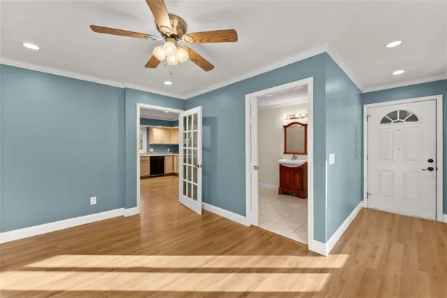 a view of a hallway with wooden floor and a ceiling fan