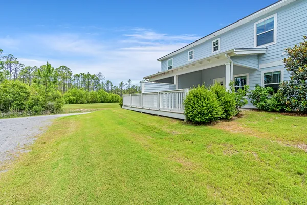 a front view of a house with a yard and trees