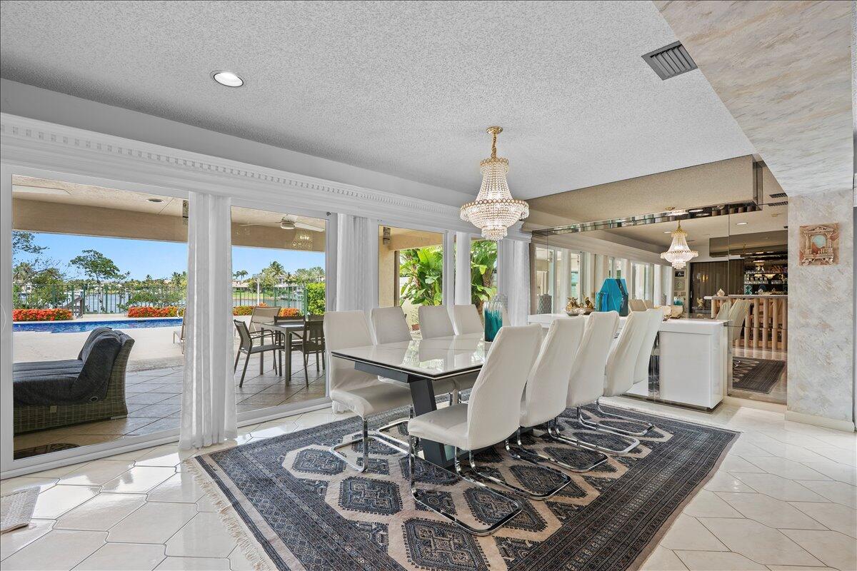 352 River Edge Road Jupiter, FL 33477 - Photo 14 of 56 a living room with furniture a dining table and a floor to ceiling window
