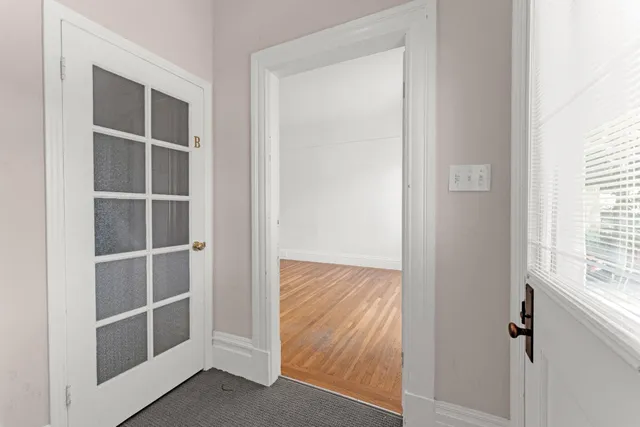a view of empty room with wooden floor and fireplace