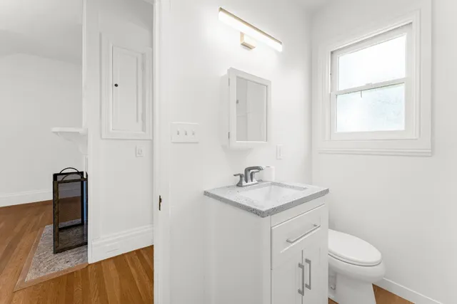 a bathroom with a toilet a sink and mirror