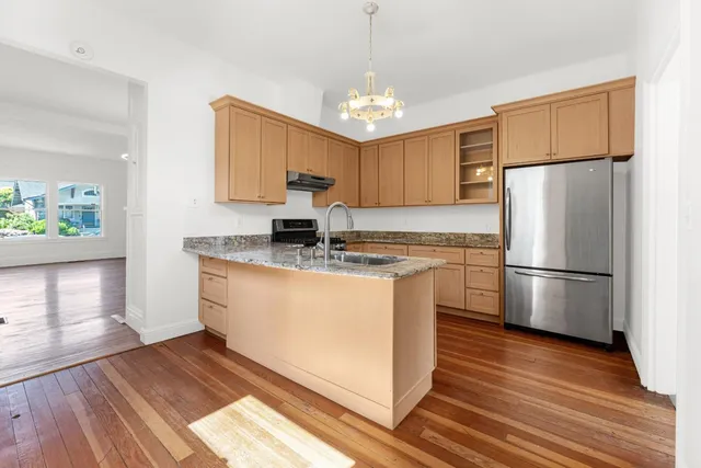 a kitchen with stainless steel appliances granite countertop a sink stove and refrigerator