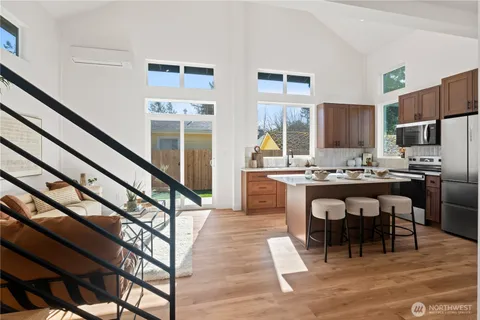 a kitchen with stainless steel appliances kitchen island granite countertop a table chairs sink and cabinets