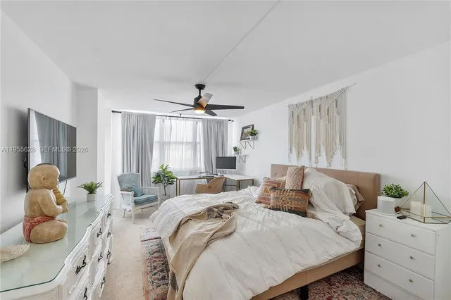 a bedroom with a bed and large windows