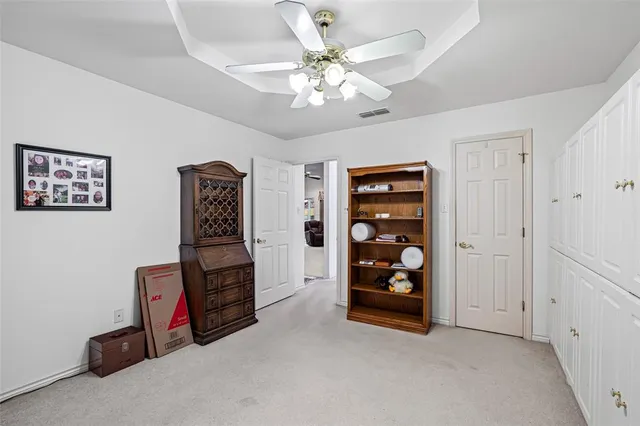 a bedroom with a bed and a potted plant on a dresser
