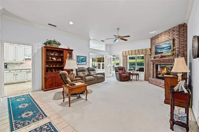 a living room with furniture a fireplace a flat screen tv and a large window
