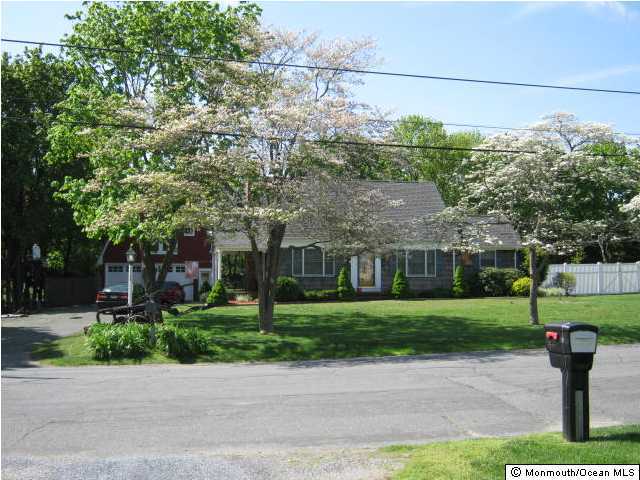 2709 Woolley Road Wall, NJ 07719 - Photo 1 of 3 a front view of a house with a garden and tree