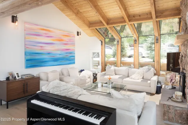 a living room with furniture a flat screen tv and a floor to ceiling window