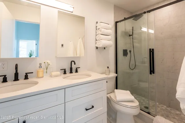 a bathroom with a granite countertop sink toilet and shower