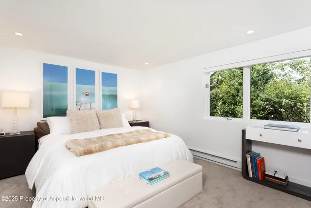 a bedroom with a bed and a large window