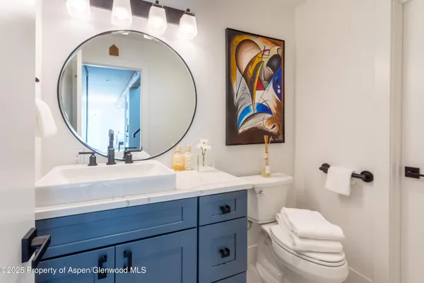 a bathroom with a toilet a sink and mirror