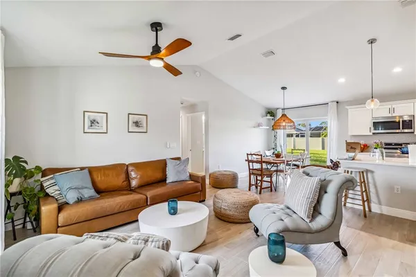 a living room with furniture kitchen view and a chandelier