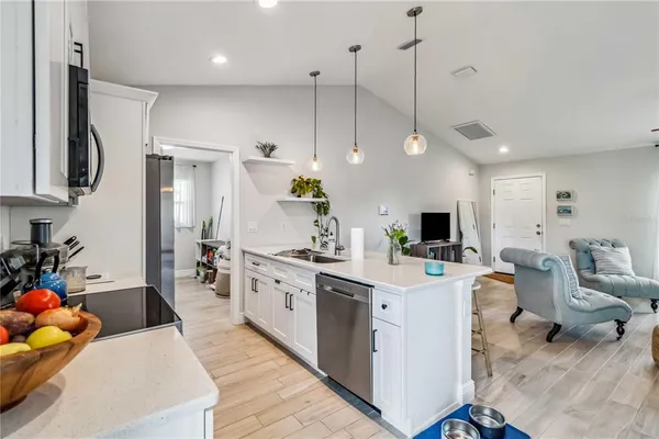 a large white kitchen with lots of counter space and sink