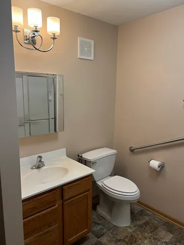 a bathroom with a toilet a sink and mirror