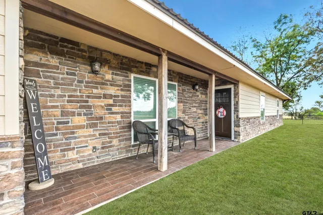 a view of a porch with a table and chairs and potted plants