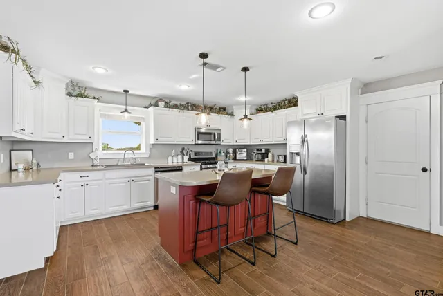 a kitchen with kitchen island granite countertop wooden floors and stainless steel appliances