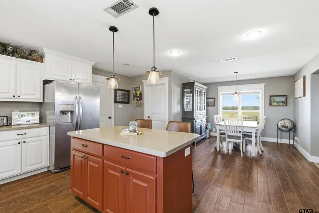 a kitchen with a table chairs refrigerator and cabinets
